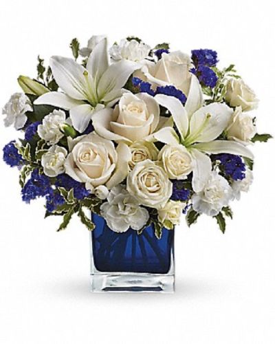 <div class="m-pdp-tabs-description">
<div id="mark-1" class="m-pdp-tabs-marketing-description">Send someone a bit of heaven with this beautiful bouquet. Luxurious crème roses and pure white lilies paint a peaceful picture inside a blue cube.</div>
</div>
<p id="arrngDescp">Crème roses, white asiatic lilies and white miniature carnations are mixed with bursts of purple statice and green pitta negra. Delivered in a glass cube.</p>